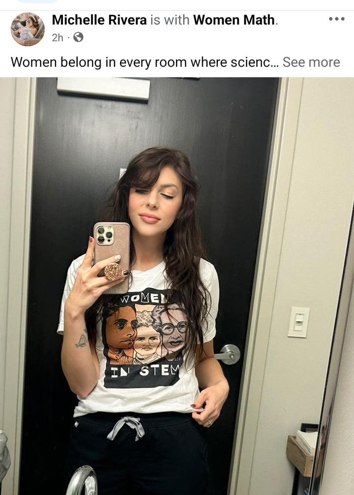 Person taking a mirror selfie wearing a graphic t-shirt with text and images.
